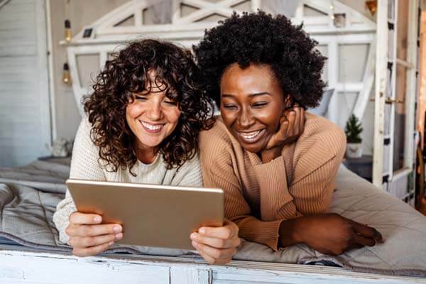 two women watching a tablet
